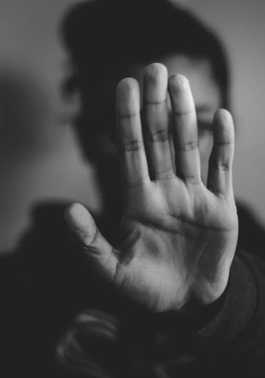 Avocat victimes d'agression Photographie en noir et blanc d'une personne tendant sa main, paume ouverte, vers l'objet et dissimulant son visage